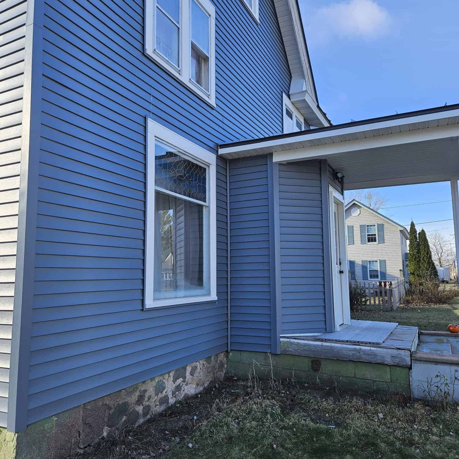 Enhanced blue siding exterior of a residential house, showcasing professional home improvement and siding installation services by AGX Home Improvement.